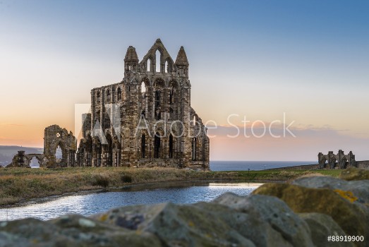 Bild på Stone ruins of Whitby Abbey on the cliffs of Whitby North Yorkshire England at sunset